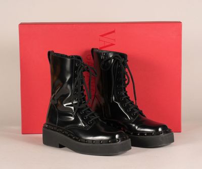 une paire de bottes militaires noires posée sur une boîte rouge