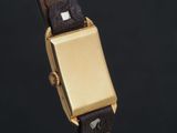 a close up of a gold watch with a black strap
