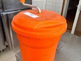 an orange bucket sitting on top of a table in a kitchen