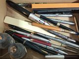 a box full of pens and pencils sitting on a table
