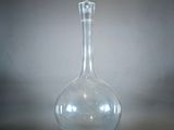 un vase en verre transparent au col long et incurvé