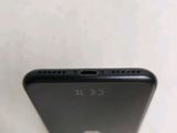 the back of a black cell phone sitting on top of a table