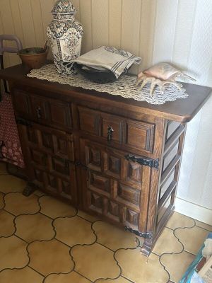 une commode sur laquelle est posé un vase, dans une pièce