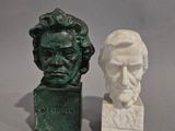 two busts of men sitting next to each other