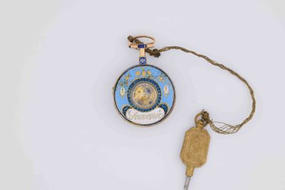 a small clock and a key attached to a chain