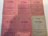 six books on a white table with pink covers on them