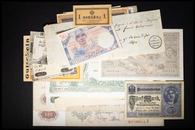some old and new currency are sitting on a black surface