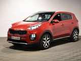 une voiture rouge garée dans un garage au sol en damier