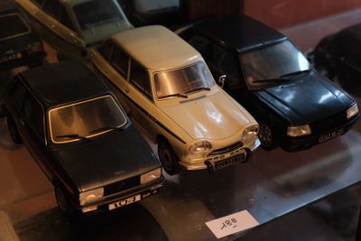 Plusieurs petites voitures sont exposées dans une vitrine.