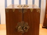a small wooden box on a table with a pair of scissors on it