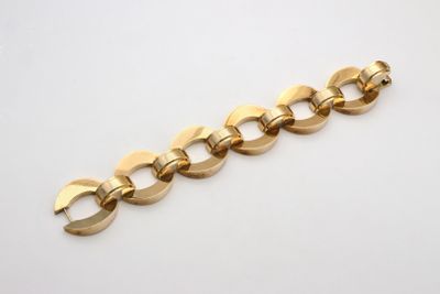 a close up of a gold chain bracelet on a white surface