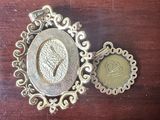 two pieces of jewelry sitting on top of a wooden table