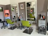 a picture of a hair salon with green chairs