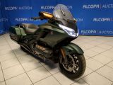 a picture of a green motorcycle parked in front of a blue backdrop
