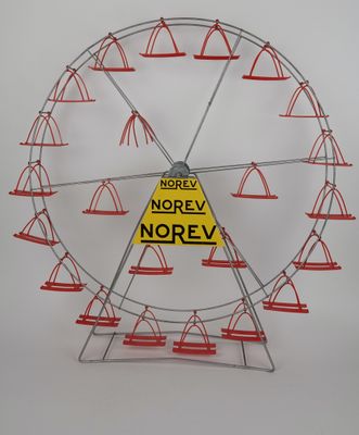 une grande roue ornée de cônes et d'un panneau sur lequel on peut lire « norev norev »