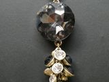 collier plaqué or avec pendentif en cristaux noirs et transparents et pompon