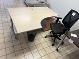 a desk with a chair and a computer on it in a room