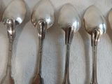 six cuillères sont alignées sur une table