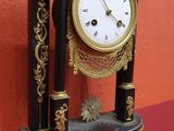 a black and gold clock on a table with a pair of scissors