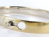a close up of a ring on a white surface with a diamond