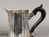 an antique silver plated pitcher with a black handle and a black handle
