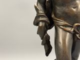 bronze statue of a man holding a piece of paper in his right hand