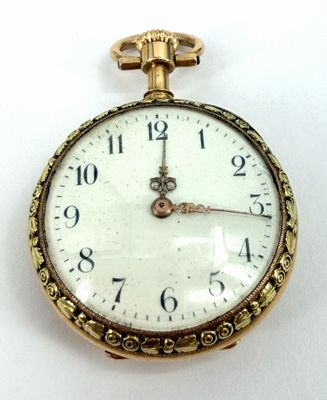 a close up of a pocket watch on a white surface