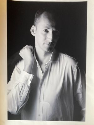 black and white photograph of a man in a shirt posing for a picture