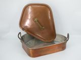 an old copper pan with a lid and handle on a white background