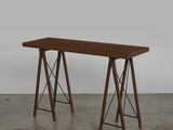 une photo d'une table en bois à deux pieds posée sur un sol en béton