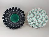 pair of black and white plates with a green center on a white background