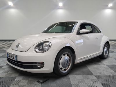 une photo d'une Coccinelle VW blanche garée dans un garage