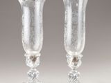 two clear glass vases sitting on top of a white table