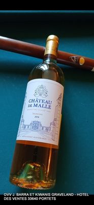 une bouteille de vin et une batte de baseball posées sur une table de billard