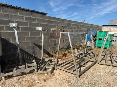 a pile of metal stands in front of a brick wall