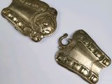 two pieces of silver metal on a white surface