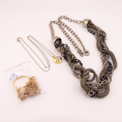 Des colliers, des bracelets et des bagues sont disposés sur une surface blanche