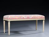 an upholstered bench with a pink and yellow floral upholstered seat