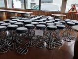 many stools and tables in a room with a lot of windows