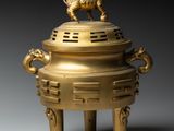 an image of a gold incense box with a lion on top