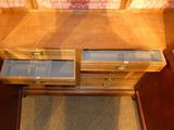 a wooden dresser with two drawers and a glass top