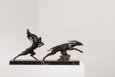 statue représentant un homme à cheval poursuivant un chien, posée sur un socle