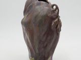 a brown vase with a face on it on a white surface
