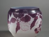 a purple and white vase with leaves on it