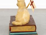 a statue of a cat sitting on a stack of books