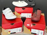 trois paires de chaussures sont posées sur des cartons posés par terre