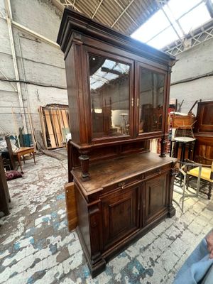 a wooden cabinet with a glass door in the middle of a room