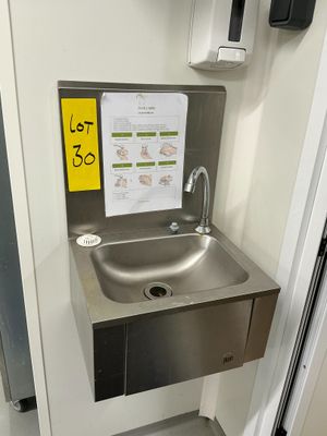 un évier en acier inoxydable dans le coin d'une salle de bains