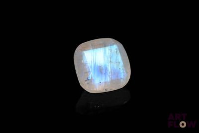 a close up of a white and blue stone on a black surface