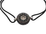 a bracelet with black and white stones on a black cord